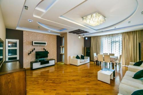 een woonkamer met een televisie en een eetkamer bij SEA ViEW HOTELAPARTMENT MCDONALD'S in Baku