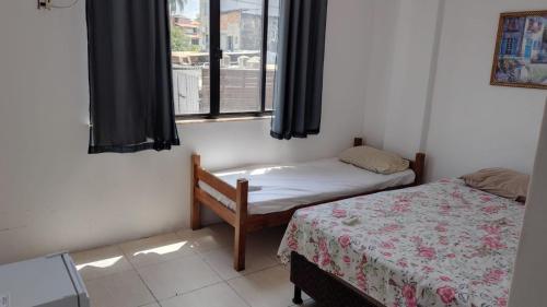 サルバドールにあるhotel praia itapuaのベッドが2つと窓のある部屋