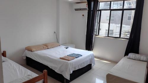 サルバドールにあるhotel praia itapuaの小さなベッドルーム(ベッド2台、窓付)