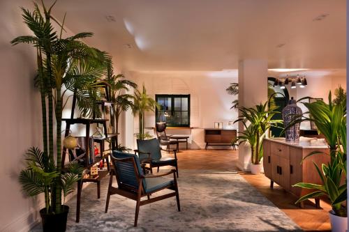a living room with chairs and plants in it at Hotel Brown Beach House & Spa in Trogir