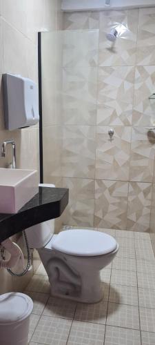 a bathroom with a toilet and a sink and a shower at Apartamento por temporada em Macapá - Edifício Fernando Dias in Macapá