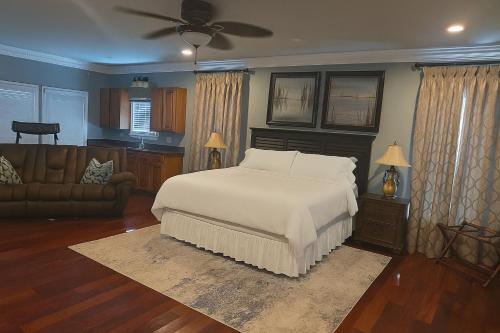 een slaapkamer met een wit bed en een bank bij Lakefront Luxury: Dock Fire Pit Game Room More in Lake Murray Shores