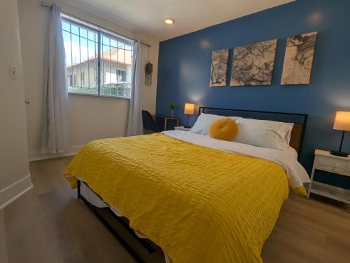 une chambre avec un grand lit avec une couverture jaune dans l'établissement Modern Cottage near many conveniences, à Oakland