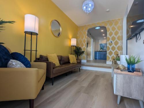 a living room with a couch and a yellow wall at Modern Cottage near many conveniences in Oakland
