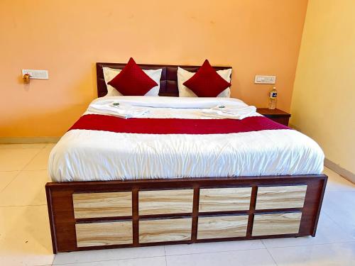 a bedroom with a large bed with red pillows at 7 Hill Stays in Panchgani