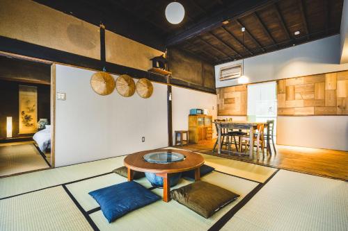 ein Wohnzimmer mit Tisch und Küche in der Unterkunft Gateway to Hakuba & Snow Monkey - Historic 200yo Home in Nagano