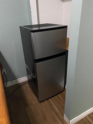 a small refrigerator in a corner of a room at Comfy Private Room in Brampton
