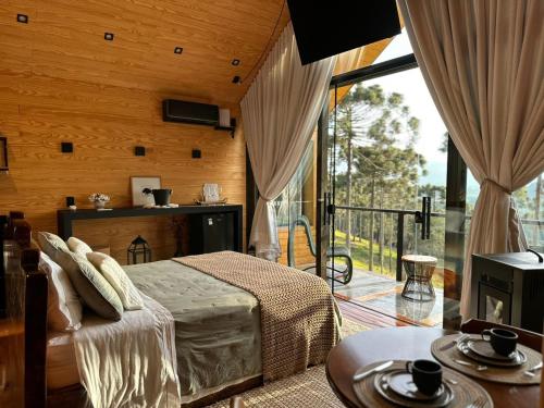 a bedroom with a bed and a balcony at Cabana Verona, Villa Itália- Urubici in Urubici