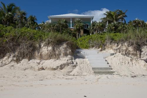 a house on the beach with stairs in the sand at Aqua Villa home in Governorʼs Harbour