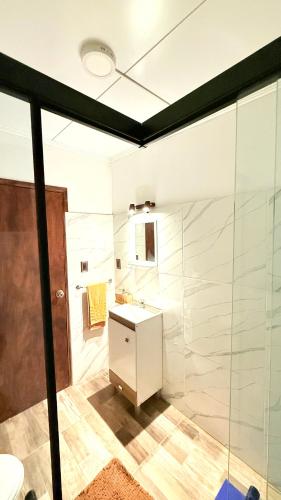 a bathroom with a white sink and a shower at Casitas Atlántida in Atlántida