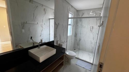 a bathroom with a sink and a toilet and a shower at Casa Estrela do Mar in Maragogi