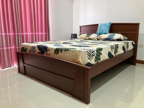 a bedroom with a bed with a wooden frame at Modern 3 BR Apt in Dehiwala