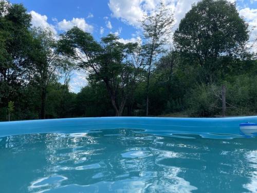 Una piscina de agua azul con árboles al fondo. en Casa de descanso, en Casa Grande