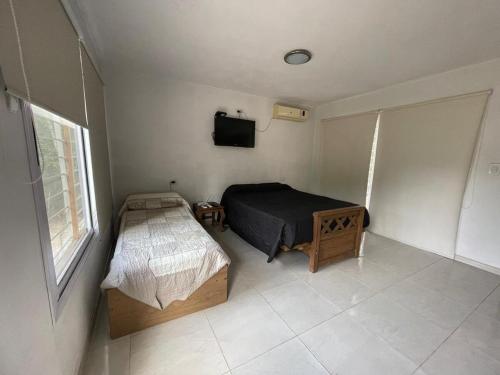 Un dormitorio con una cama y un televisor en la pared. en Casa de descanso, en Casa Grande