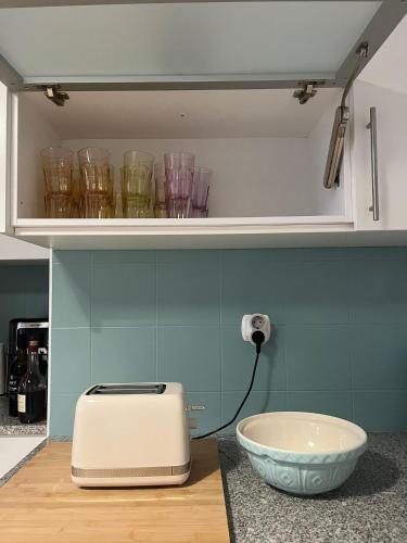 a kitchen with a bowl on a counter with a toaster at Portas Residence, Quartos & Suites - Ponta Delgada City Center in Ponta Delgada