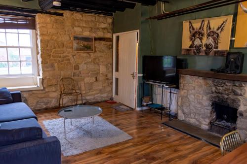 a living room with a couch and a fireplace at Countrylife Cottage for Groups- BBQ , firepit, free parking in Lincoln