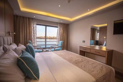a hotel room with a large bed and a table at Grand Square Hostel Luxor in Luxor