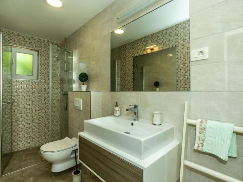 Un baño con lavabo blanco y inodoro. en Two-Bedroom Holiday Home With Pool, en Brodarica