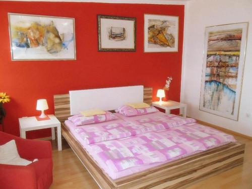 a bedroom with a bed and a red wall at Charming Apartments Kestenovi Dvori- 2 Bedroom A1 in Opric