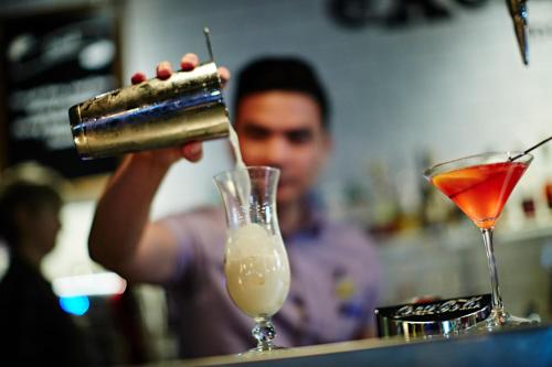a man is making a drink at a bar at Novotel Manchester Centre in Manchester