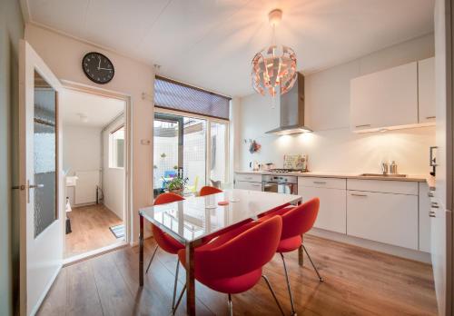 a kitchen with a glass table and red chairs at Stay 19 - 2 bedroom hotelapartment with free parking in Groningen