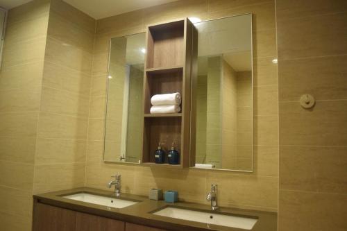 a bathroom with two sinks and a large mirror at By The Sea - SDBMS in Batu Ferringhi
