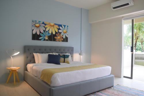 a bedroom with a bed with a painting on the wall at By The Sea - SDBMS in Batu Ferringhi