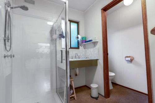 a bathroom with a shower and a sink at Jetty View - Pelican Cabin in Nungurner