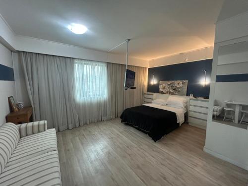 a bedroom with a bed and a couch in it at Hotel Luxuoso Moema Shopping Ibirapuera 1806 in Sao Paulo