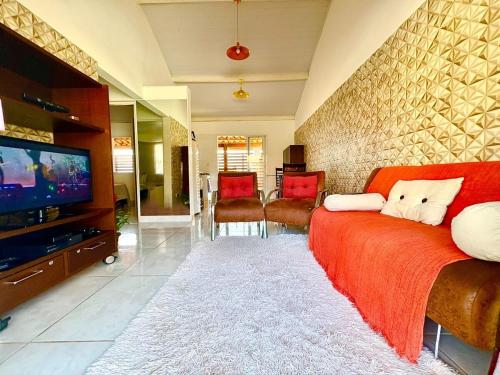 a living room with a red couch and a tv at Lindo Chalé No Campo no Catarina Home Club em mairinque in Mairinque