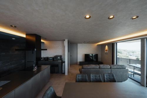a kitchen and living room with a couch and a television at AWAJI OCEAN BASE east coast in Awaji