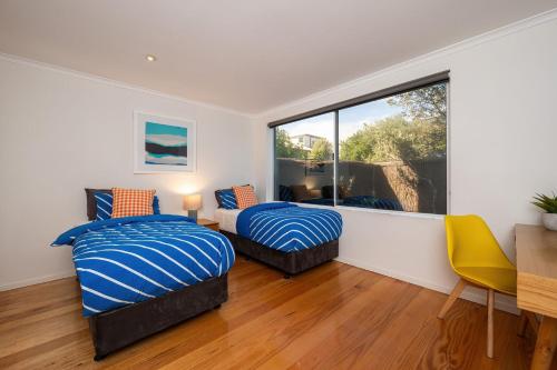 a bedroom with two beds and a window at Anchor Beachfront - Pet Friendly on the Beach in Frankston