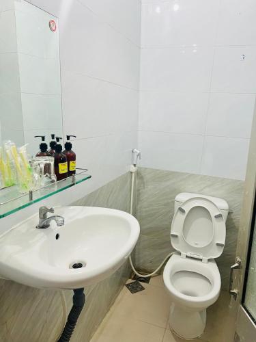 a bathroom with a sink and a toilet and a mirror at An Long Hotel in Ấp Ðông An (1)