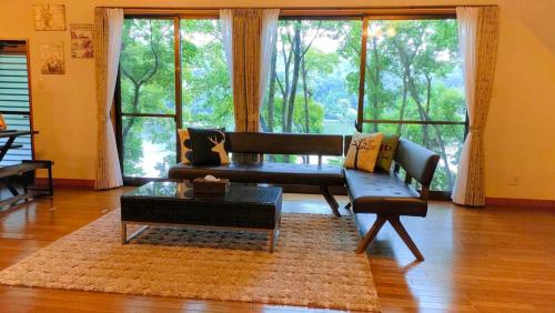 a living room with a couch and a large window at 貸別荘 時々チョコレート in Kofu