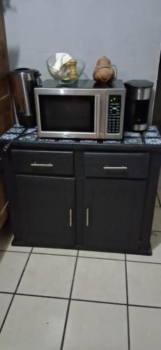a microwave sitting on top of a counter in a kitchen at Cativa CozyHomestay in Hermosillo