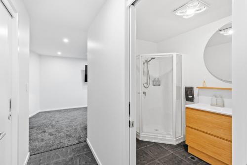 a white bathroom with a sink and a mirror at The Prescription Pad - Group Getaway for Families in Port Sorell