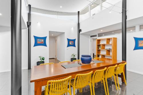a dining room with a table and yellow chairs at The Prescription Pad - Group Getaway for Families in Port Sorell