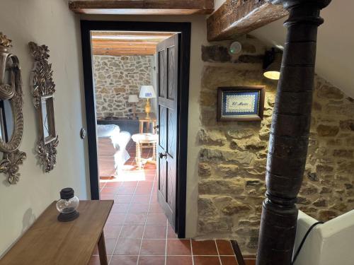 a hallway leading to a room with a stone wall at El Rincón de la Tía Miguela in Puertomingalvo