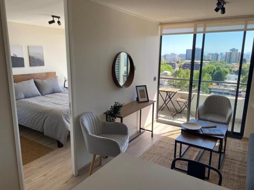 a bedroom with a bed and a desk and a mirror at Nuñoa a un paso de todo lo que necesitas in Santiago