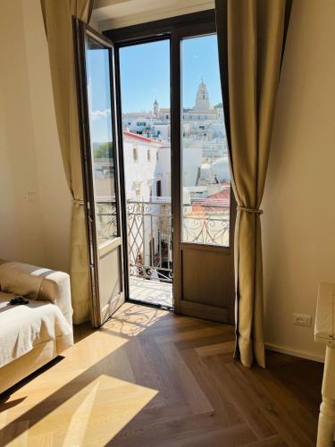a bedroom with a large window with a view of a city at Cuore Antico - Il Monastero Sul Mare in Vieste