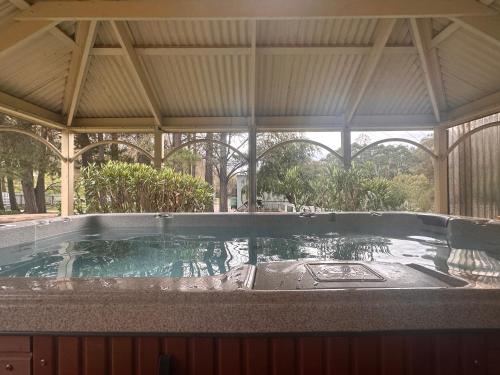 a large swimming pool in a building with anophe at Adelaide Hills Farm Stay