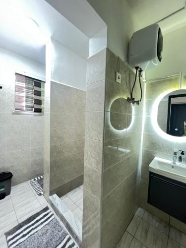a bathroom with a shower and a sink at Cozy Lovely 1 bedroom apartment in Tema