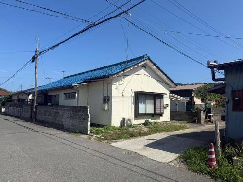 a white house on the side of a street at Ku-chan House in Tateyama