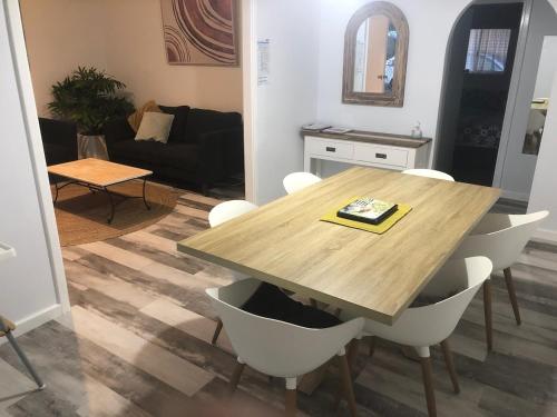 un soggiorno con tavolo e sedie in legno di Chevy Cottage a Esperance