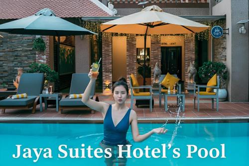 a woman in the pool with a glass of wine at Jaya Suites Hotel in Phnom Penh