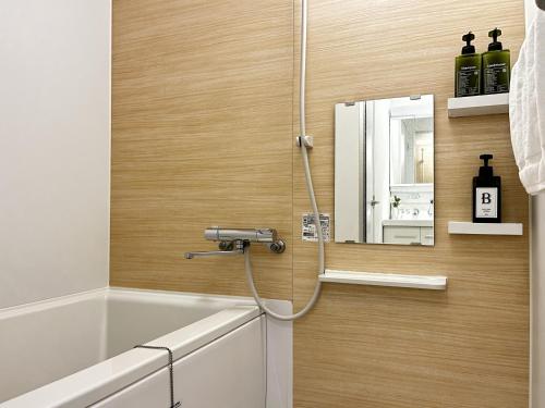 a shower with a hose attached to a wall at Roppongi Place in Tokyo