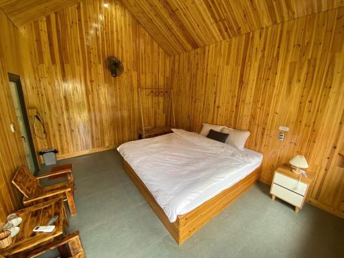 a bedroom with a bed in a wooden room at Chúng Pả Homestay in Mia Xu