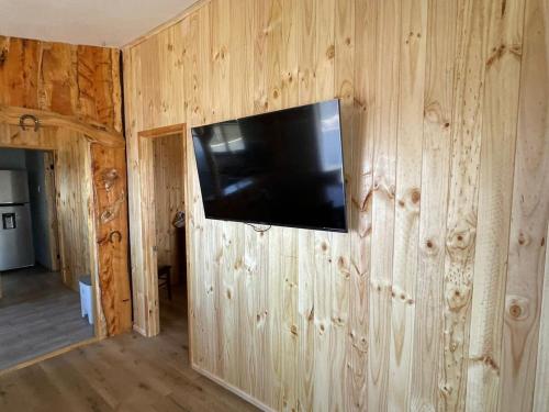 a flat screen tv on a wooden wall in a room at Casa Mirada Azul in Isla Negra