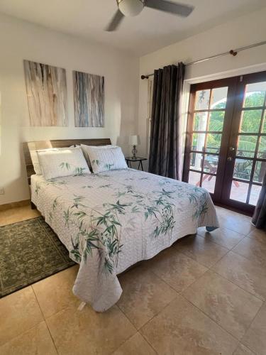 a bedroom with a large bed and a window at Oistins Gem 2BR, 2BA Condo, Pool & Rooftop Patio, Walk to Miami Beach in Christ Church