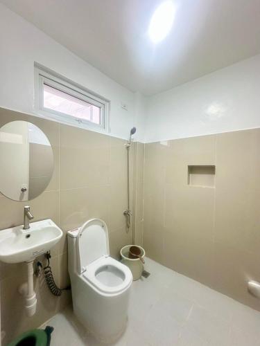 a bathroom with a toilet and a sink and a mirror at JEMZ Tagaytay Budget Transient in Kaybagal